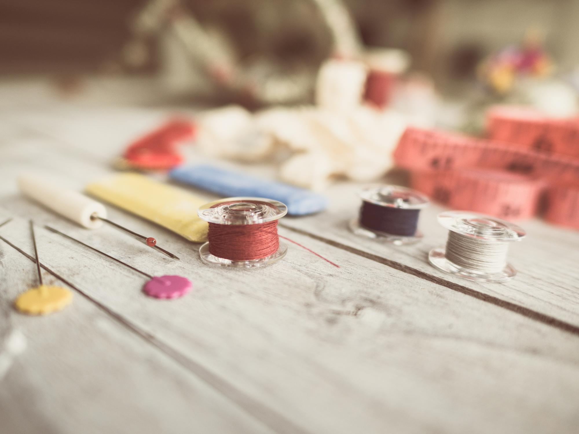 Workshop table with threads, needles and linen samples